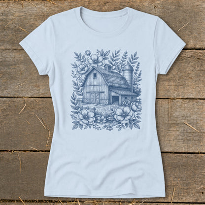 Light blue t-shirt with a blue line drawing of a barn and silo surrounded by flowers.