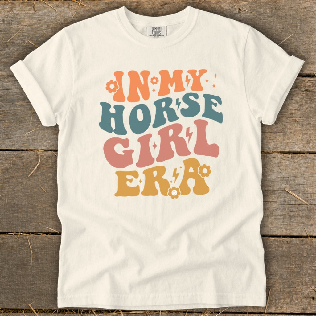 Cream t-shirt with "IN MY HORSE GIRL ERA" text in retro colorful font.