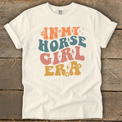 Cream t-shirt with "IN MY HORSE GIRL ERA" text in retro colorful font.
