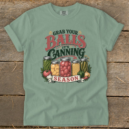 Green t-shirt with "Grab Your Balls It's Canning Season" and jarred vegetables graphic.