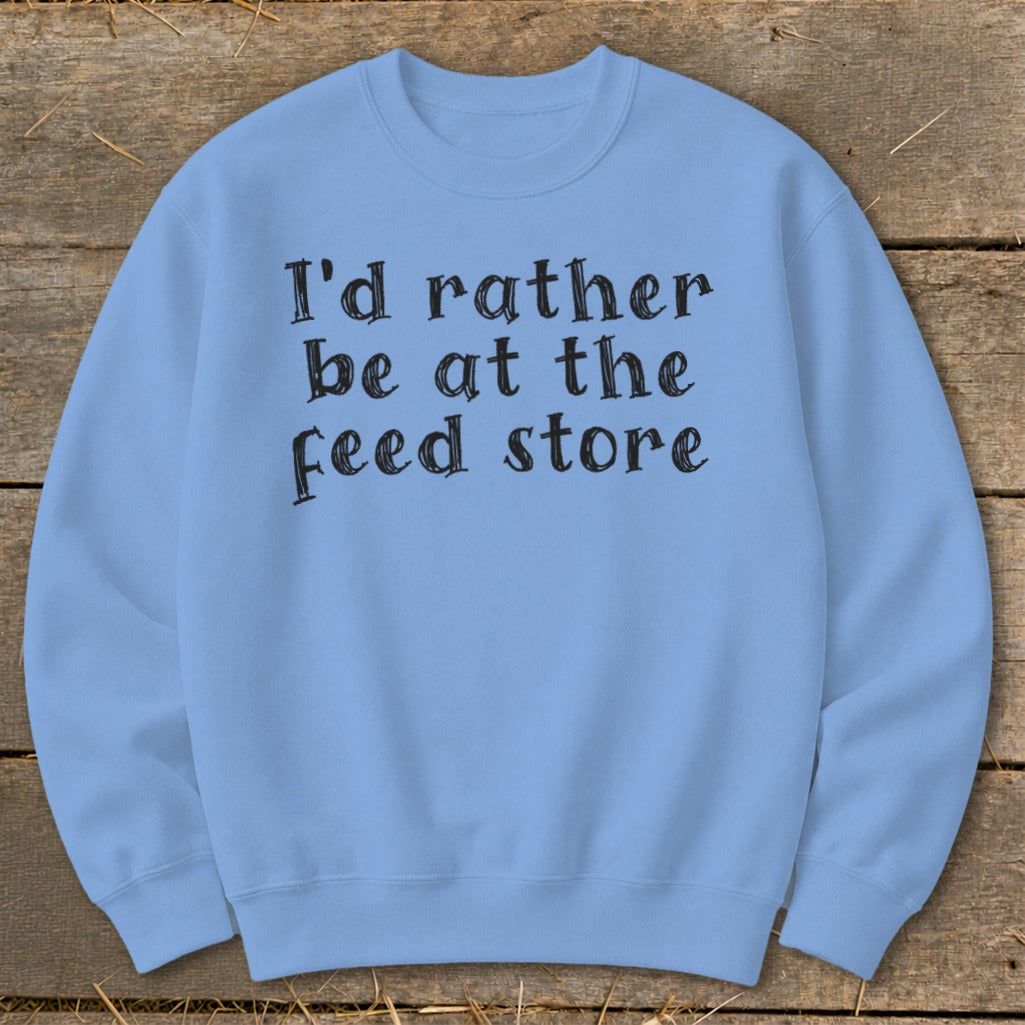 Light blue sweatshirt with black text that reads "I'd rather be at the feed store".