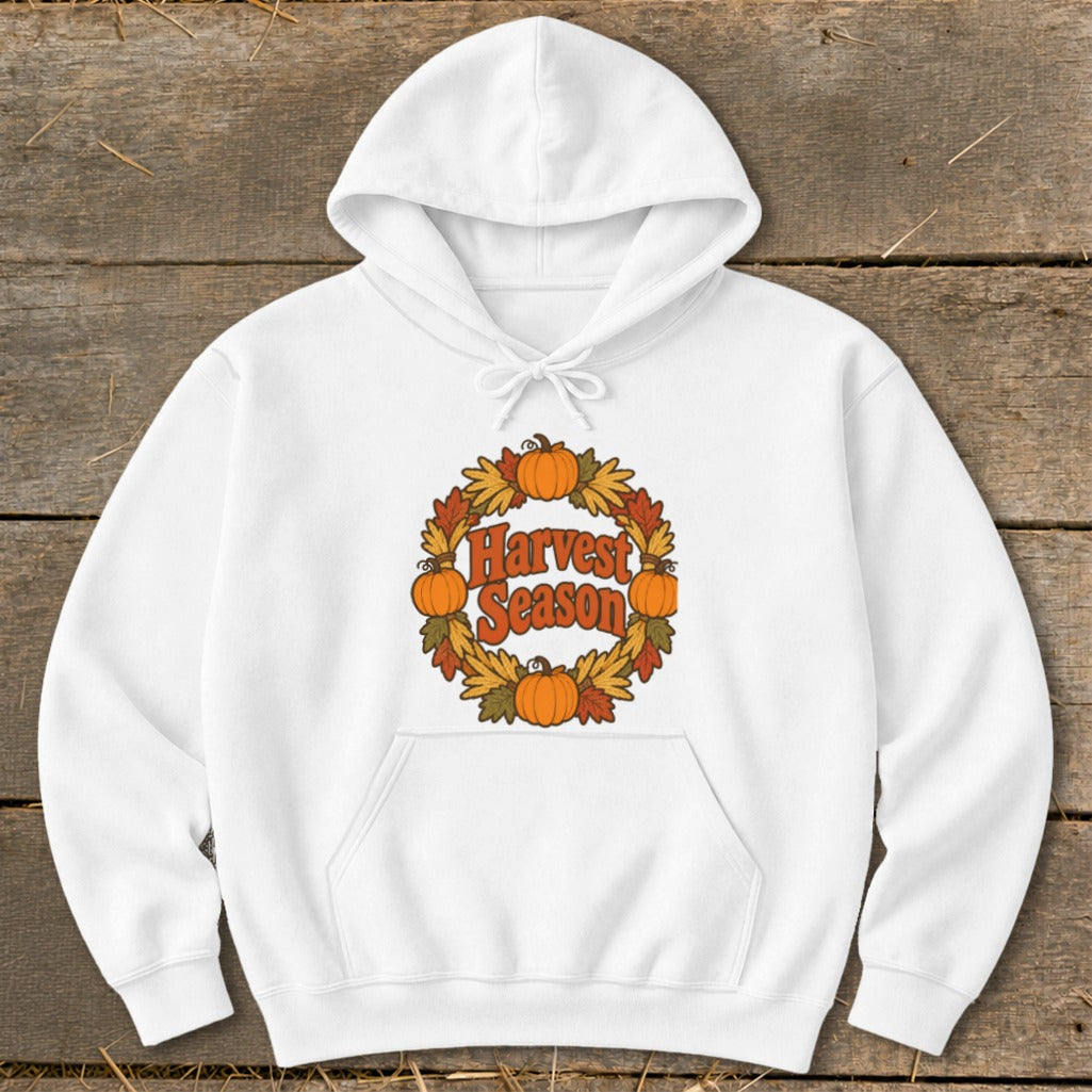 White hoodie with "Harvest Season" text surrounded by pumpkins and fall leaves.