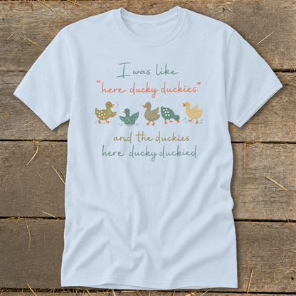 Light blue t-shirt with text and a row of five colorful ducks.