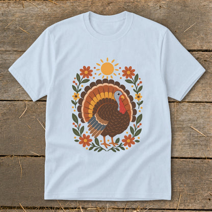 Light blue t-shirt with a colorful turkey design surrounded by flowers and a sun.