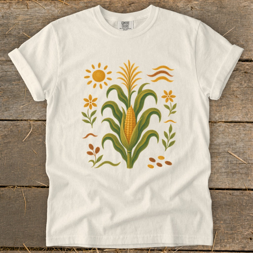 White t-shirt with corn stalk, sun, and floral graphic.