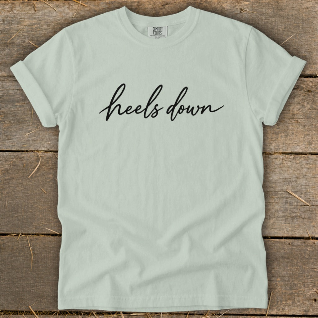 Light green t-shirt with "heels down" in black script text.