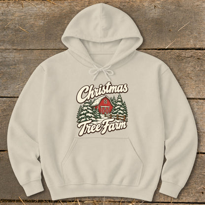 Beige hoodie with "Christmas Tree Farm" graphic featuring a red barn and snow-covered trees.