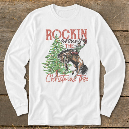 White long-sleeve shirt with a rodeo rider and Christmas tree graphic that reads "Rockin Around The Christmas Tree."