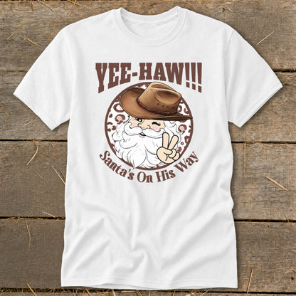 White t-shirt with Santa wearing a cowboy hat, text "Yee-Haw!!!" and "Santa's On His Way".