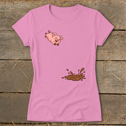 Pink t-shirt with a cartoon pig jumping over a mud puddle graphic.
