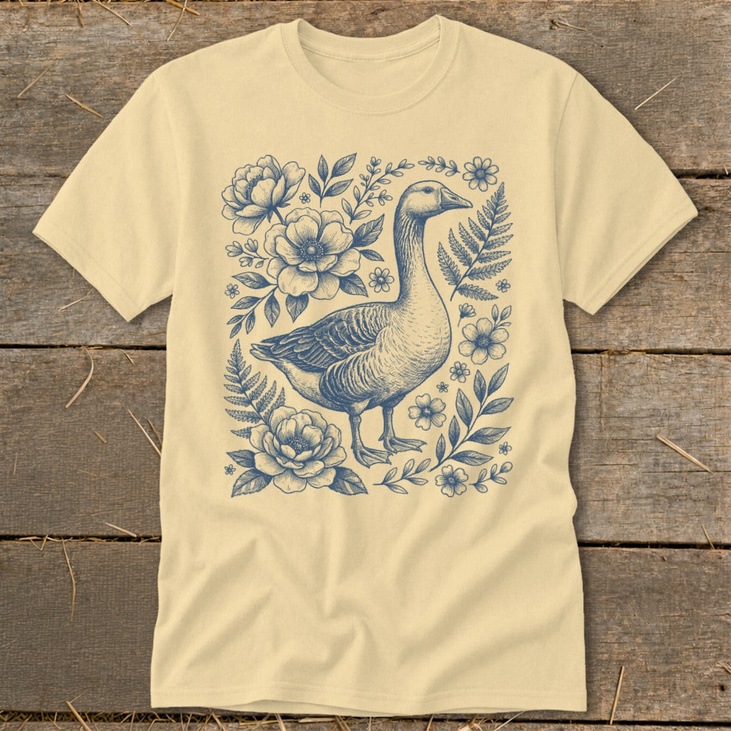 Cream t-shirt with blue ink drawing of a goose surrounded by flowers and foliage.