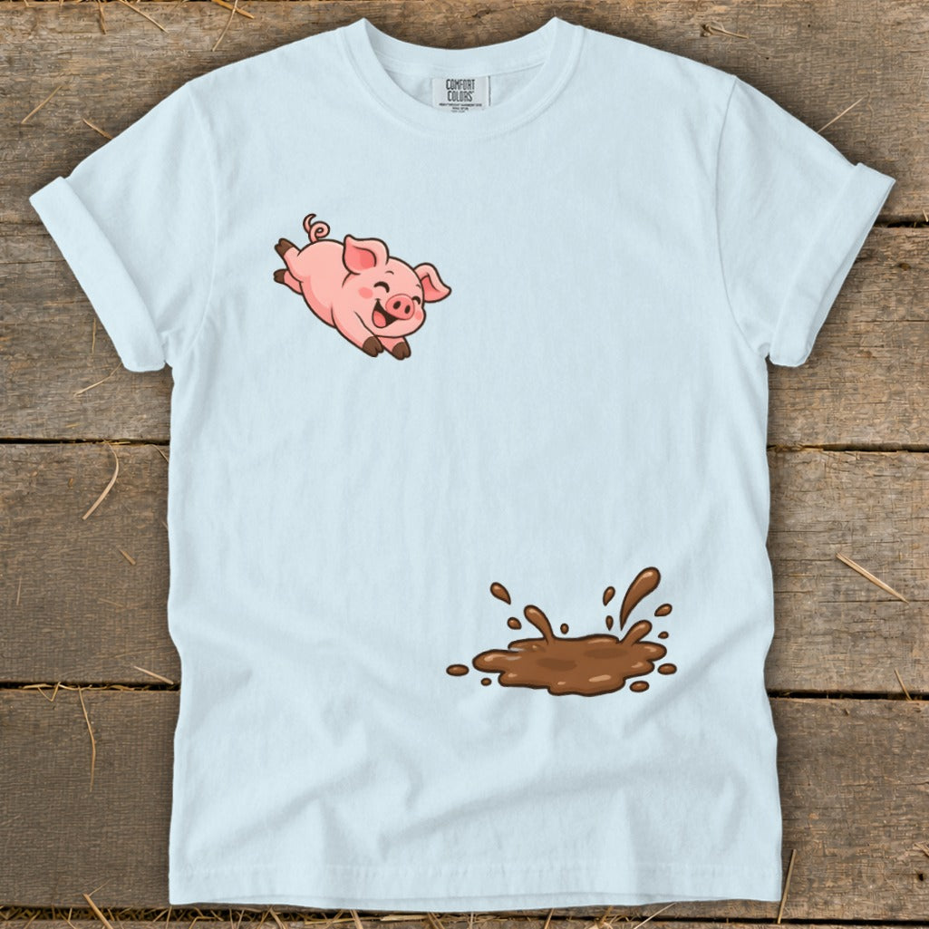 White t-shirt with a cartoon pig jumping over a mud puddle.