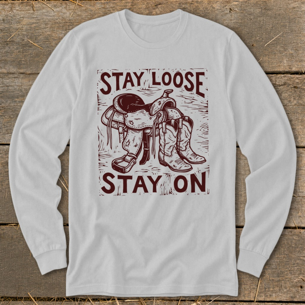 Long sleeve shirt with a cowboy saddle, boots, and "STAY LOOSE STAY ON" text.