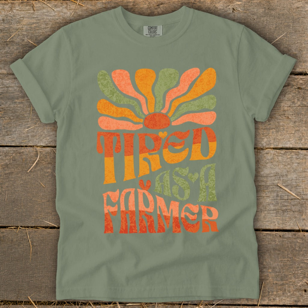 Green t-shirt with "Tired as a Farmer" text and a retro sun graphic.