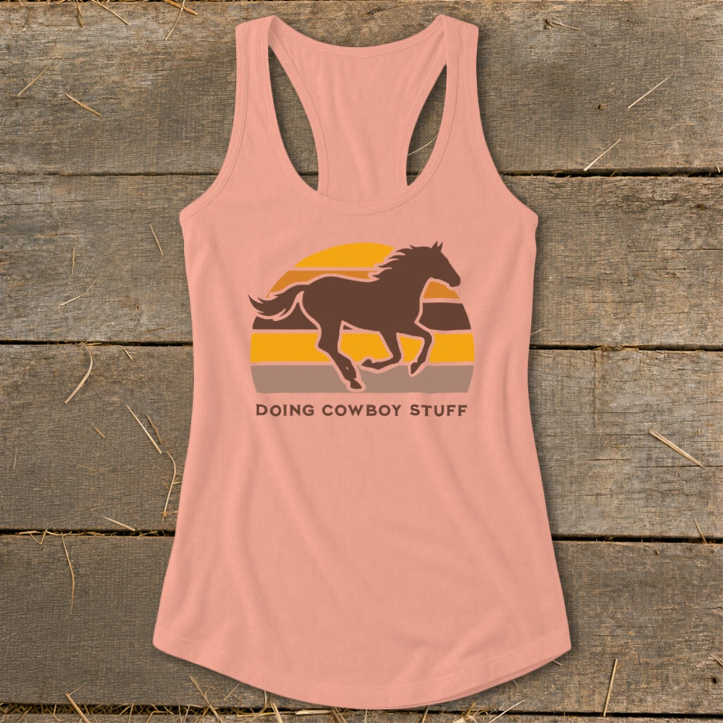 Peach tank top with a running horse and sunset graphic and "DOING COWBOY STUFF" text.
