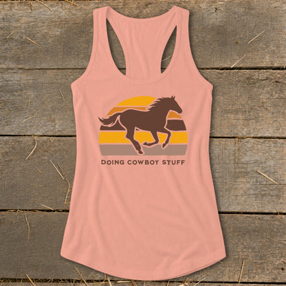 Peach tank top with a running horse and sunset graphic and "DOING COWBOY STUFF" text.